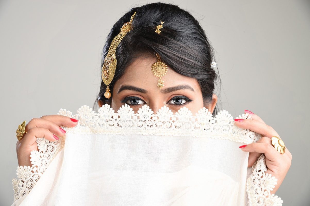 Bride Wearing Indian Wedding Attire With Veil and Maang Tikka Hair Accessory